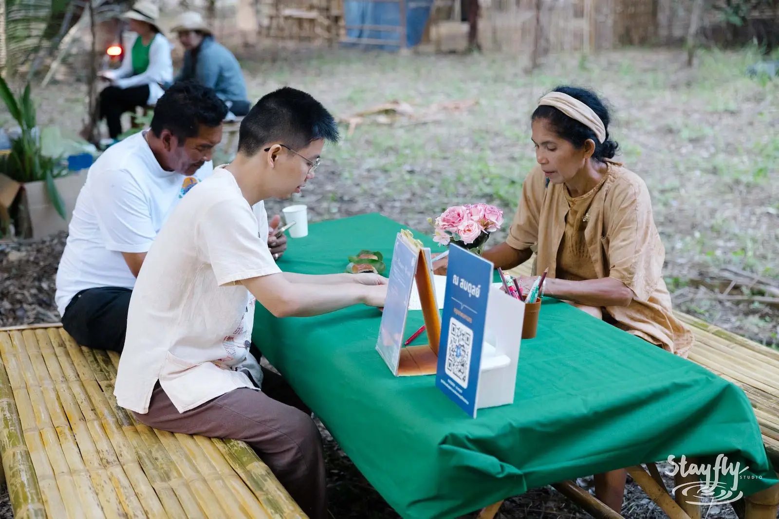 People filling out form at check-in table.